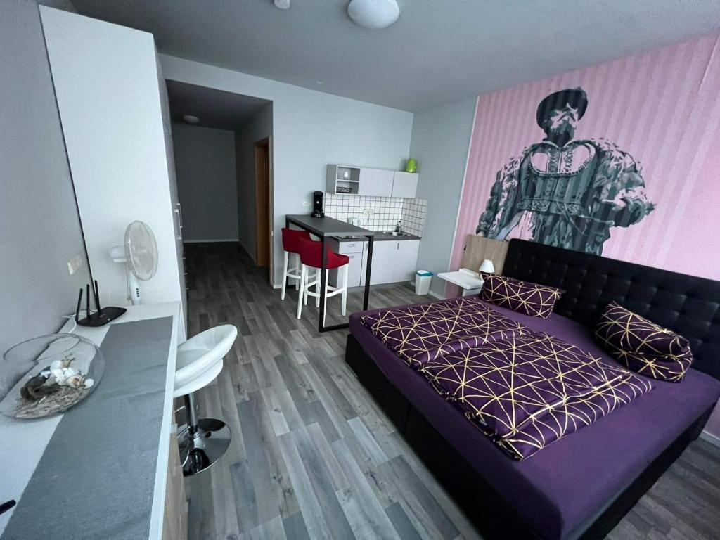 ein Schlafzimmer mit einem lila Bett, einem Tisch und einem Schreibtisch in der Unterkunft MIDTOWN Apartments in Stuttgart