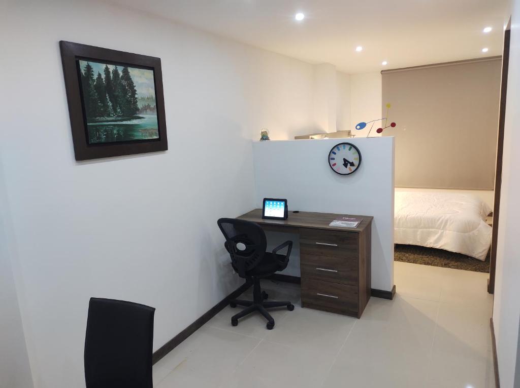 a room with a desk and a bed and a clock at Casa Almendro in Chía