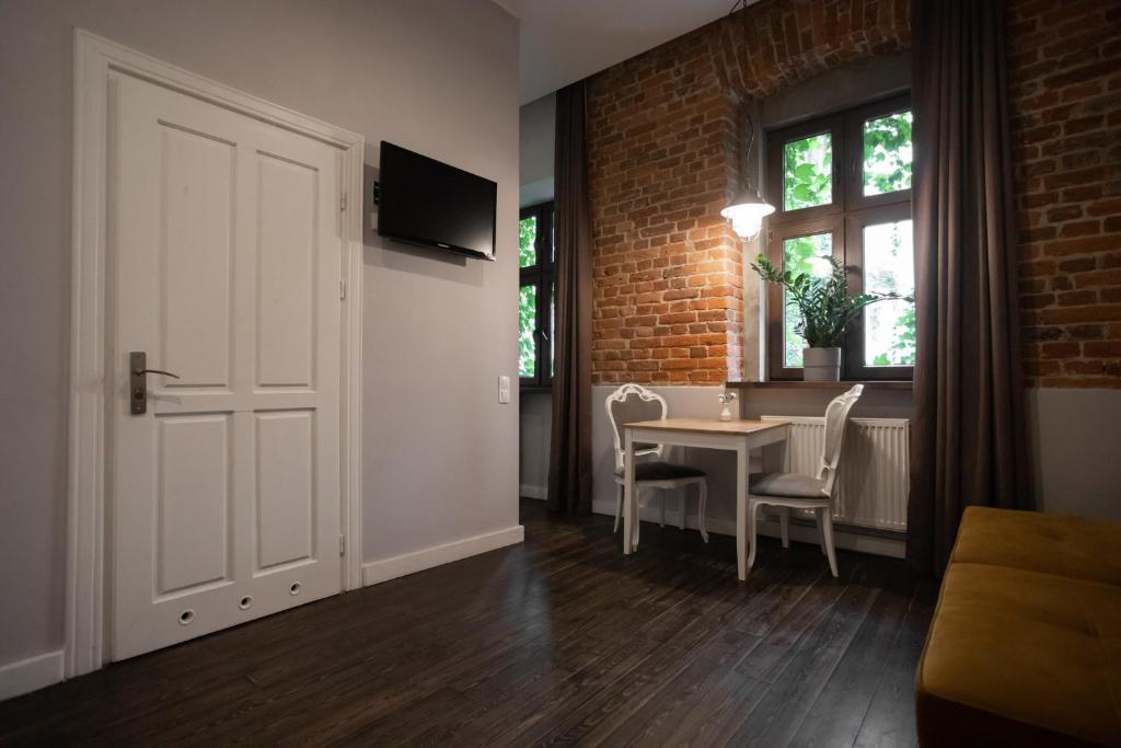 um quarto com uma porta branca e uma mesa e cadeiras em Apartament Atłasowy by Good Time em Lódź
