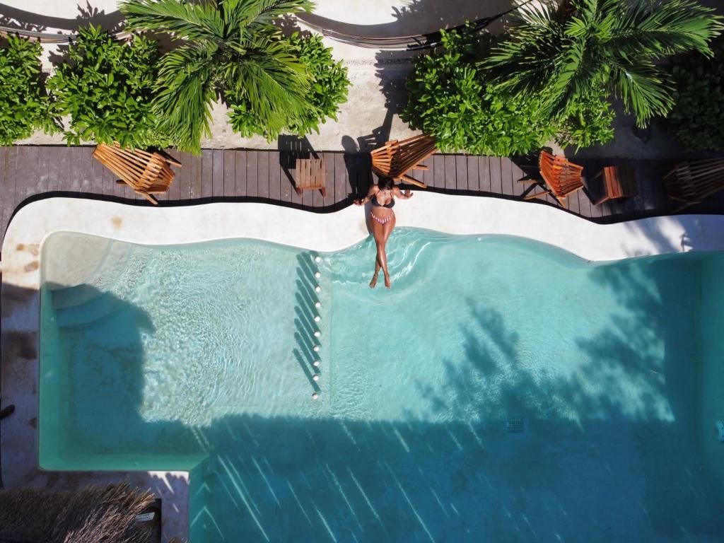 an overhead view of a woman standing in a swimming pool at Mis Sueños Holbox in Holbox Island