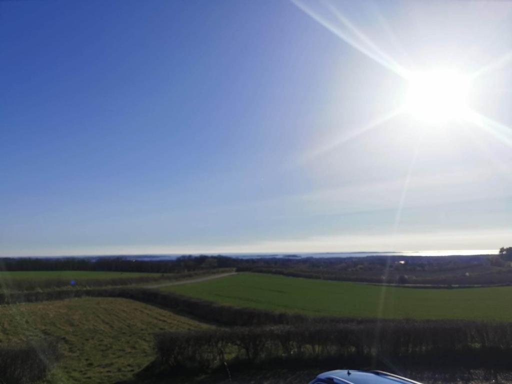 a view of a field with the sun in the sky at Håstrups Natur Perle in Fåborg