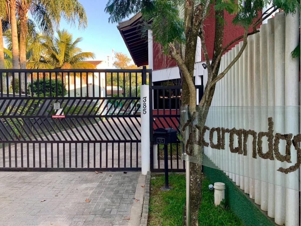 a black fence with a tree next to a building at Casa Clean e Comfort, a mais completa de Paúba in São Sebastião