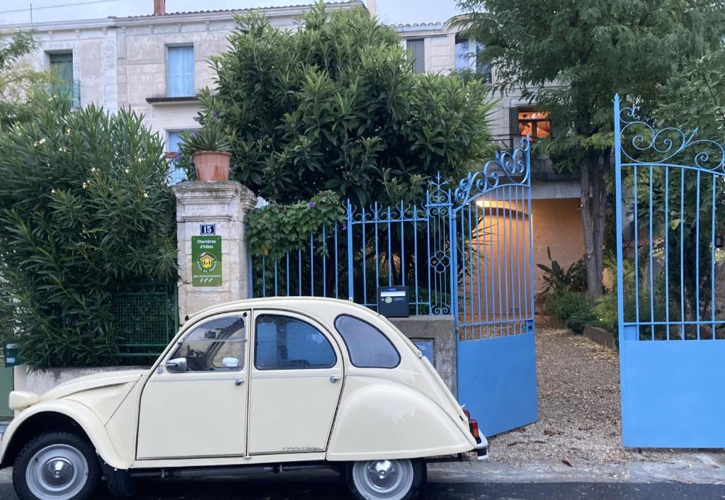 un pequeño coche blanco estacionado frente a una puerta en Chambre d'Hôtes Lo Componaïro, en Pouzols