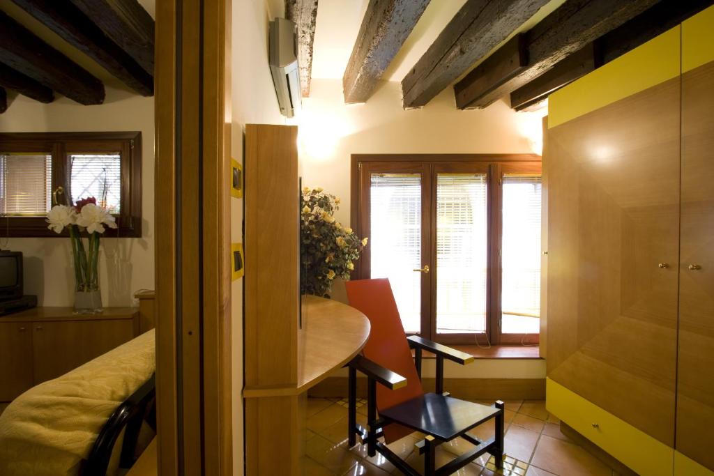 a room with a bedroom with a table and a chair at I Gioielli del Doge - Topazio in Venice