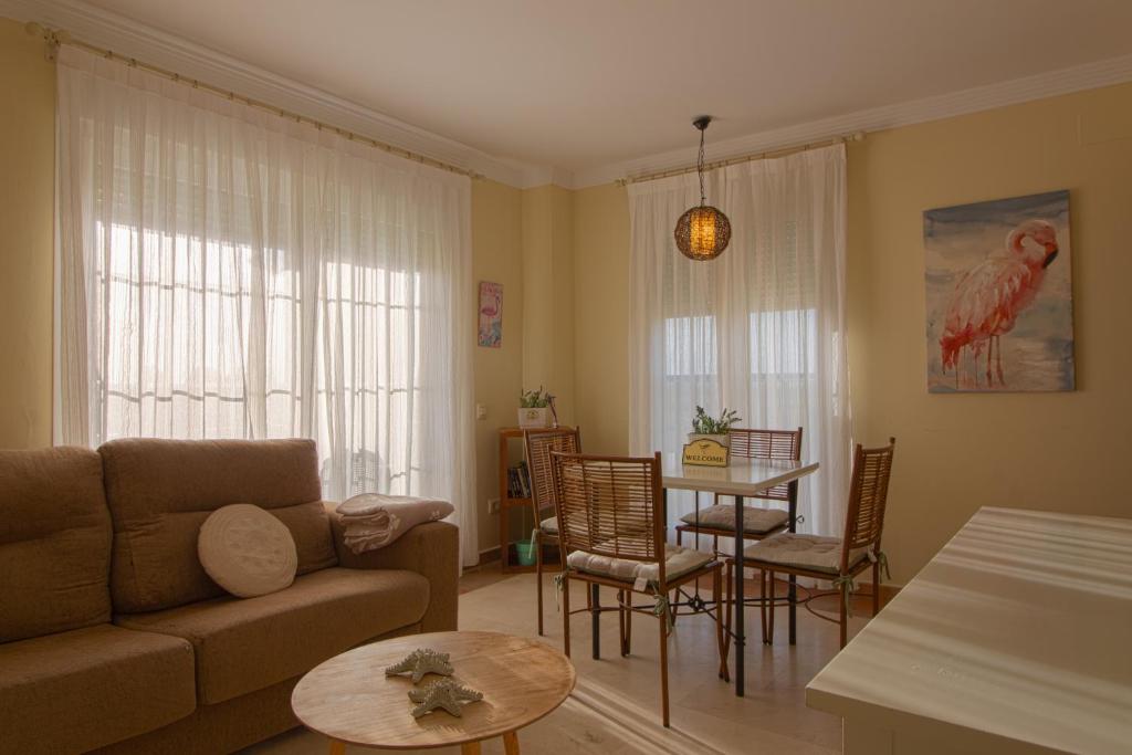 Apartment Isla Canela Luxury في هويلفا: غرفة معيشة مع أريكة وطاولة