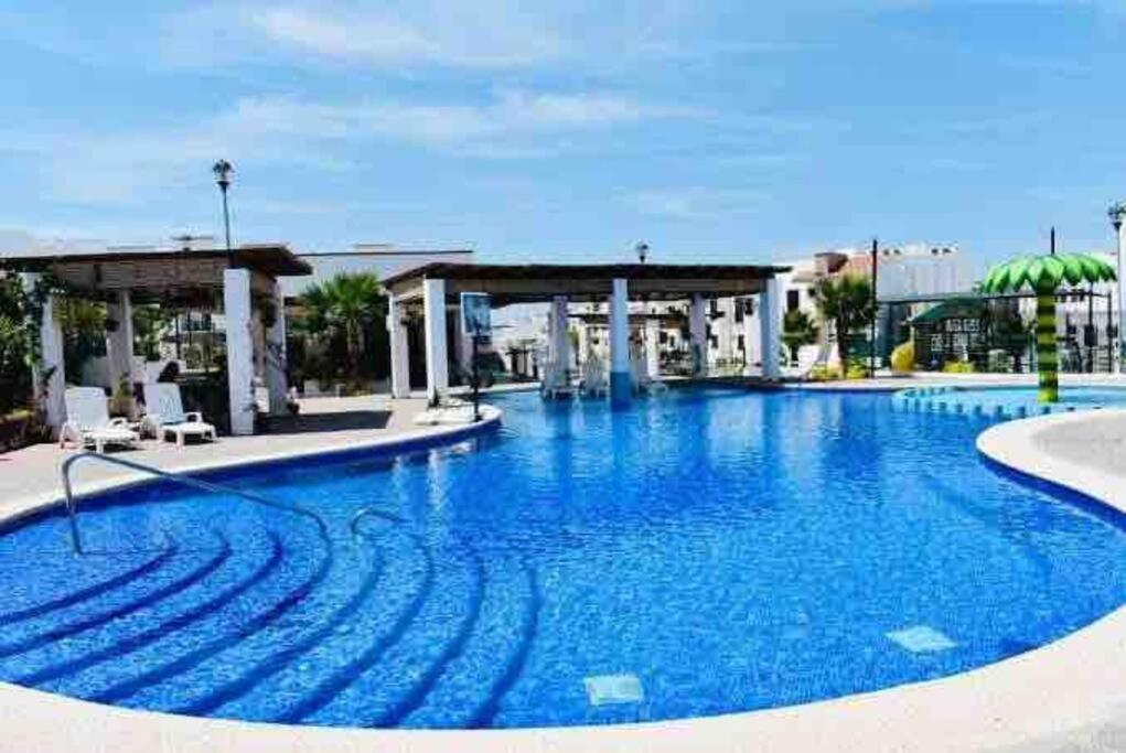 a large swimming pool with blue water at Departamento completo para 6 personas in Mazatlán