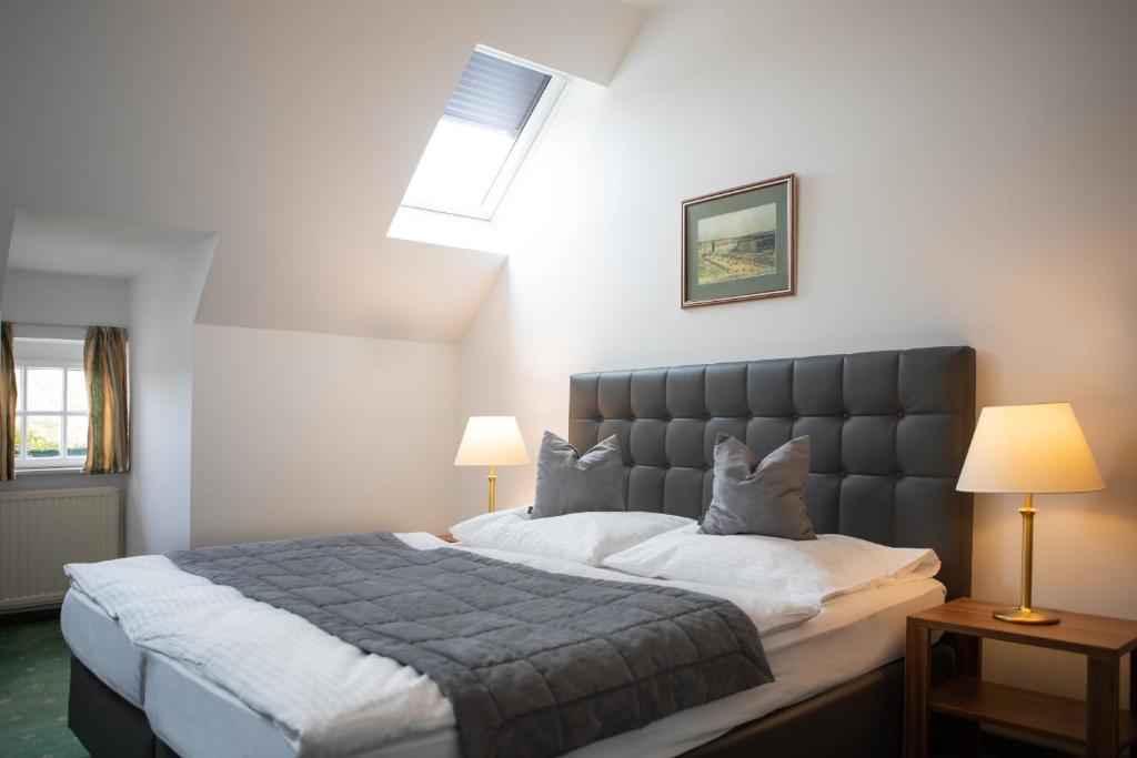 a bedroom with a large bed and two lamps at Hotel Bergwirt Schönbrunn in Vienna