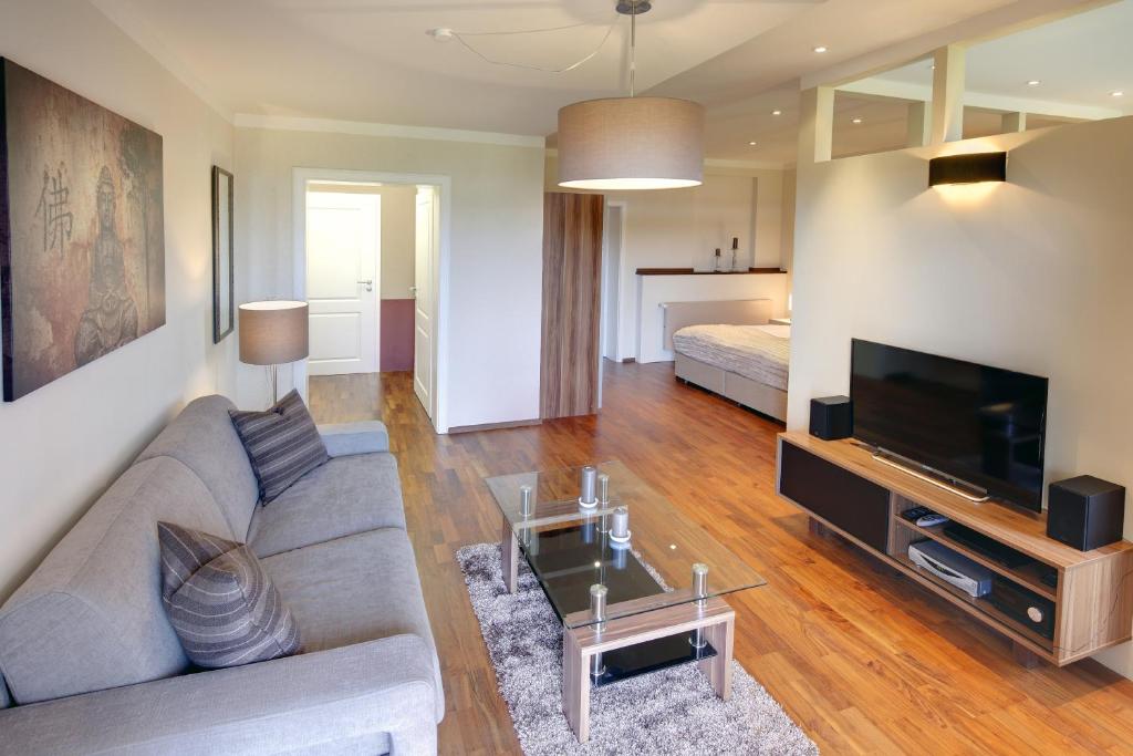 ein Wohnzimmer mit einem Sofa und einem TV in der Unterkunft Appartements Coloman in Schwangau