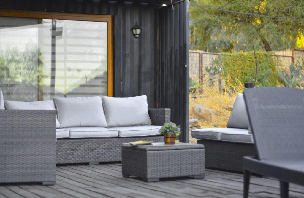 un patio con sofá, mesa y sillas en AzulZenLodge en Paine
