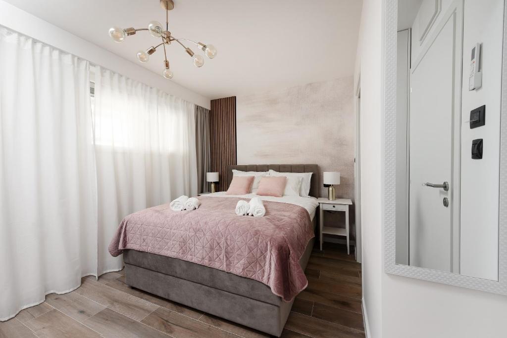 a bedroom with a bed with two towels on it at Aura Exclusive Apartment & Room in Zadar