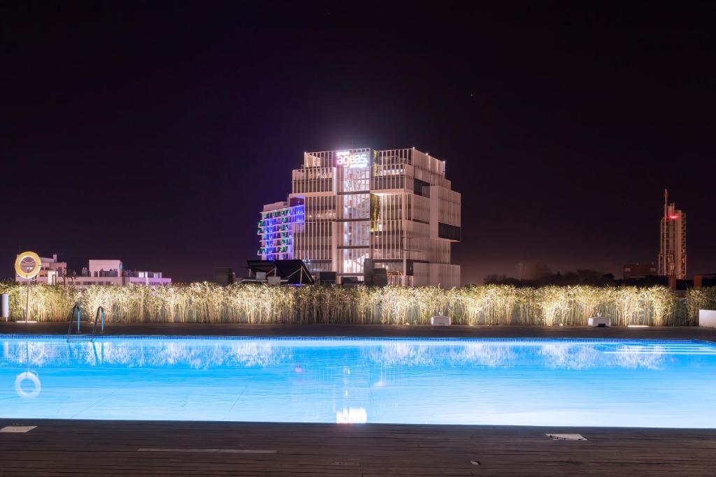 una piscina con un edificio sullo sfondo di notte di Expo River View a Lisbona