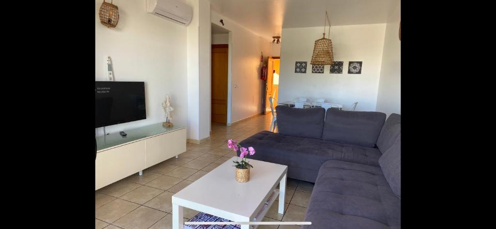 a living room with a blue couch and a tv at La Mundial Formentera in Es Pujols