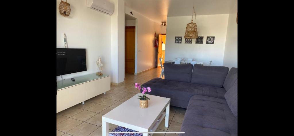 sala de estar con sofá azul y TV en La Mundial Formentera en Es Pujols