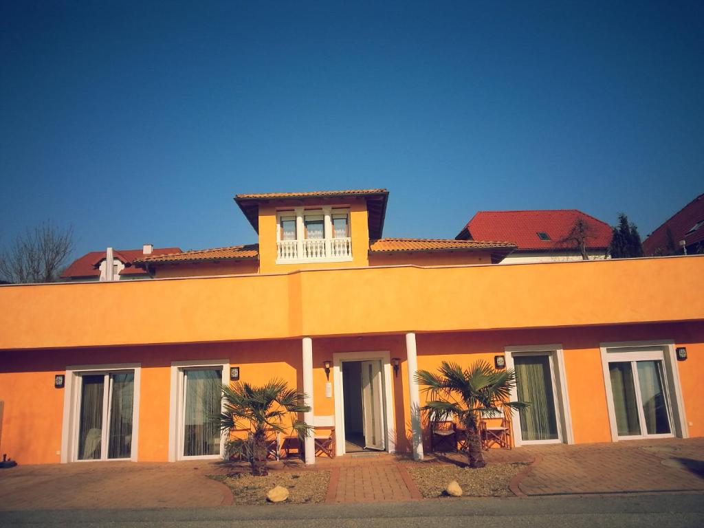 ein orangefarbenes Gebäude mit Palmen davor in der Unterkunft Villa Toscana in Steyr
