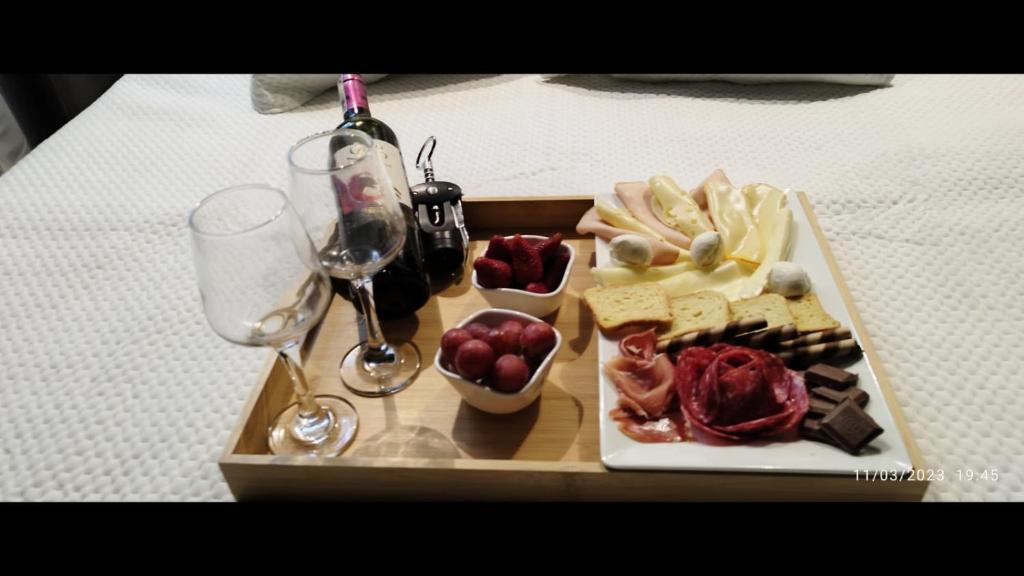 a tray of food on a table with wine glasses at Glamping MINKAWAY in Santa Marta