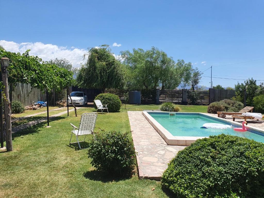 un patio con piscina y 2 sillas en Casa al Pie de los Andes en Luján de Cuyo