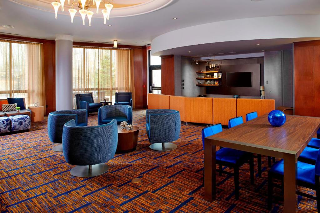 格林斯堡的住宿－匹茲堡格林萬怡酒店，酒店大堂设有桌椅和沙发。