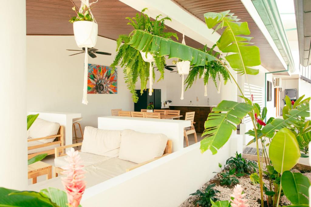ein Wohnzimmer mit Pflanzen und einer weißen Couch in der Unterkunft Hotel Por Que No? in Uvita