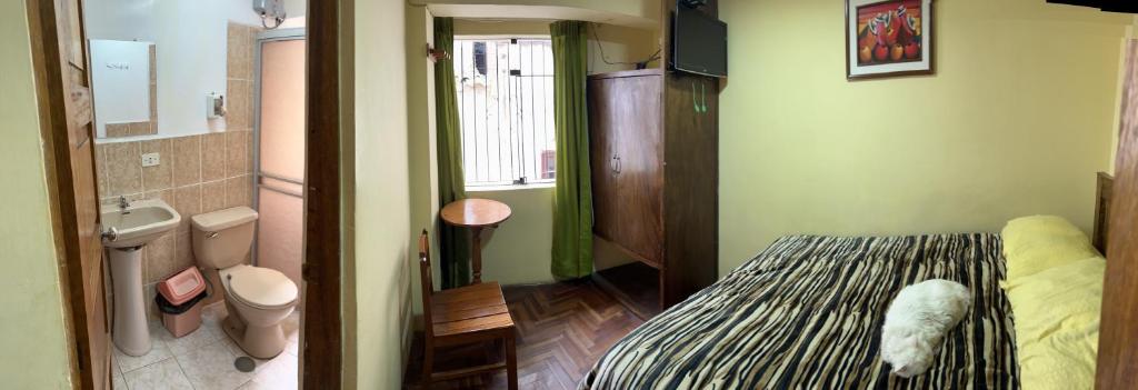 Habitación pequeña con cama y baño. en Euro Hostal, en Cusco