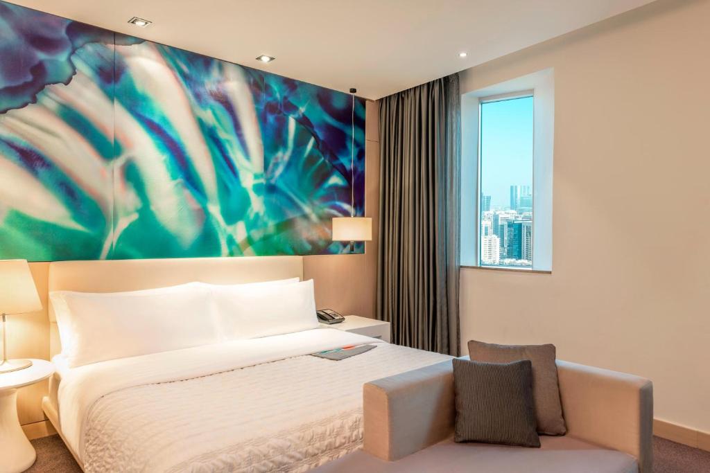 a bedroom with a bed and a large painting on the wall at Le Royal Meridien Abu Dhabi in Abu Dhabi