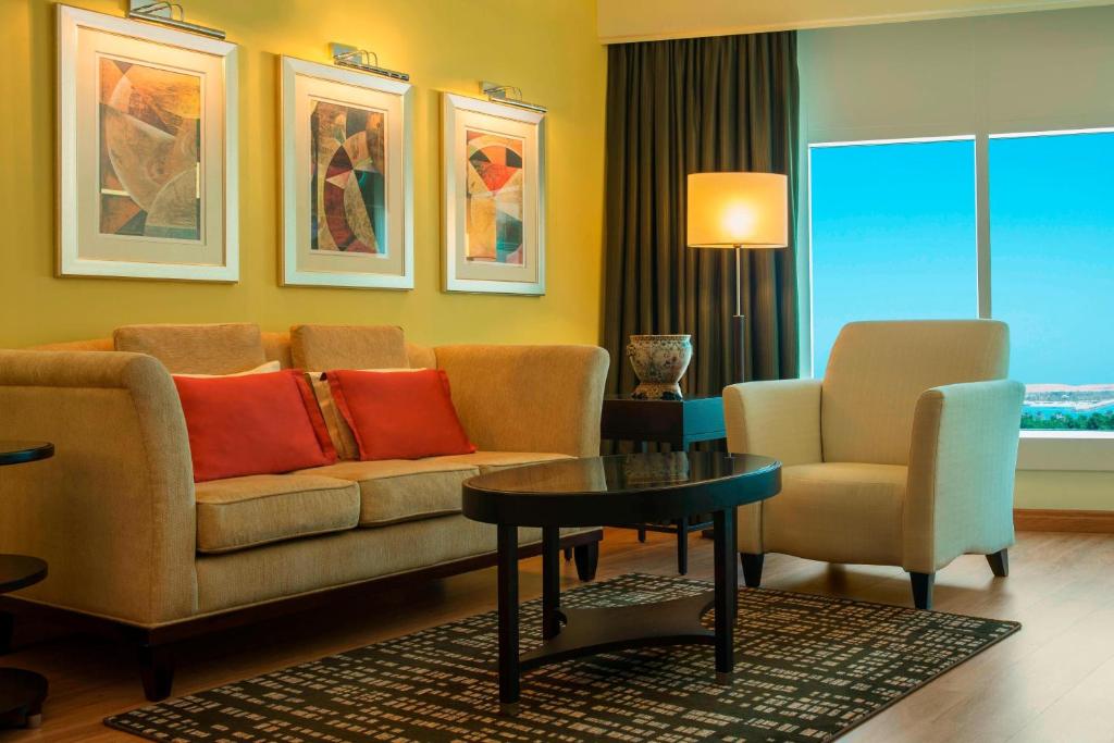 a living room with a couch and two chairs and a table at Le Royal Meridien Abu Dhabi in Abu Dhabi