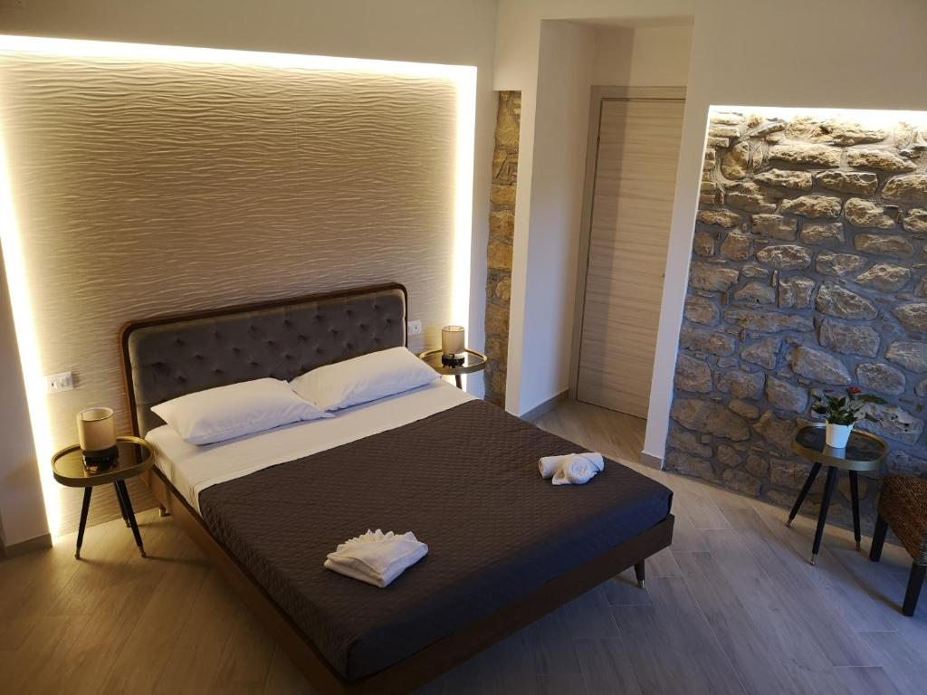 a bedroom with a bed with a stone wall at Panorama Suite in Piazza Armerina