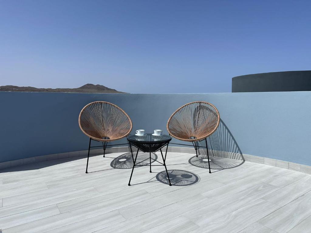 3 sillas y una mesa en una habitación en Casa Nordeste con piscina Casilla de Costa, en La Oliva