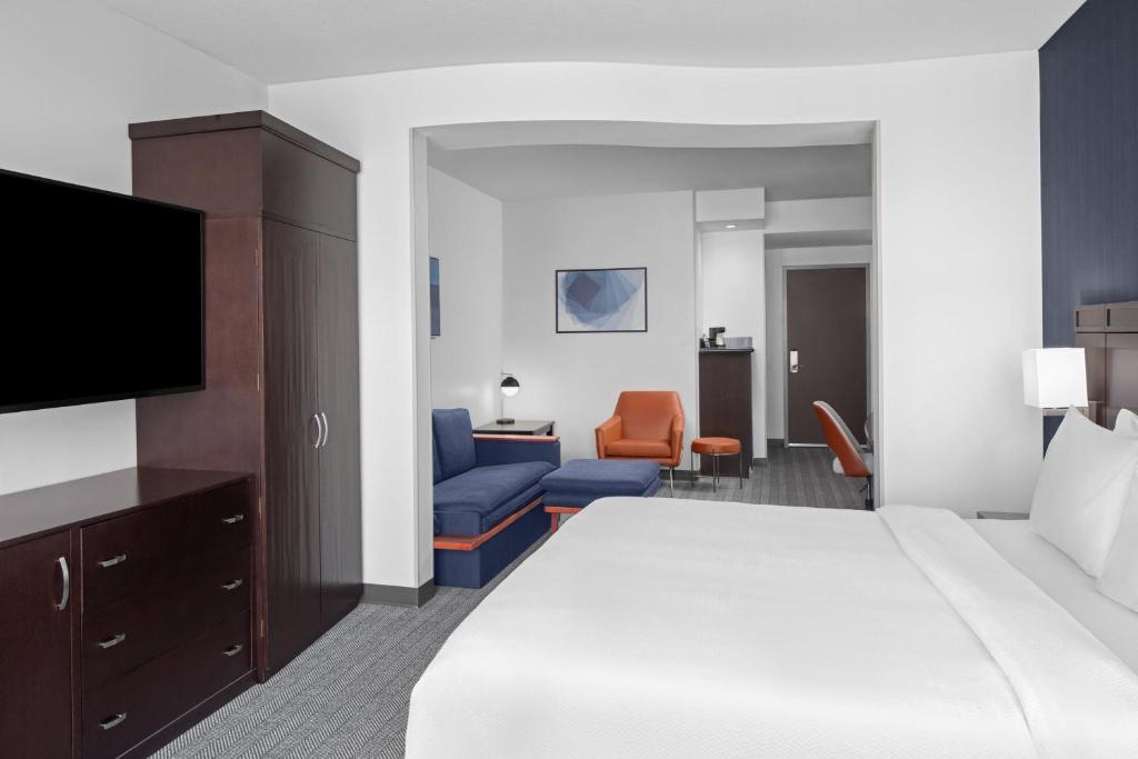 a hotel room with a bed and a flat screen tv at Courtyard Cleveland University Circle in Cleveland
