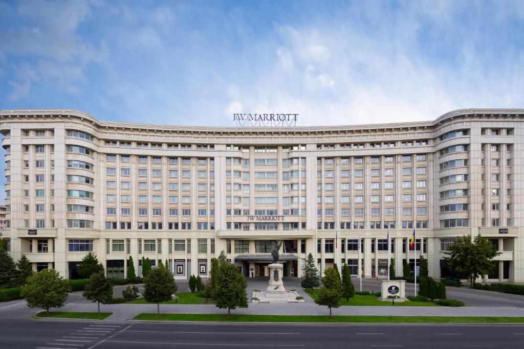 un gran edificio blanco con un cartel encima en JW Marriott Bucharest Grand Hotel, en Bucarest