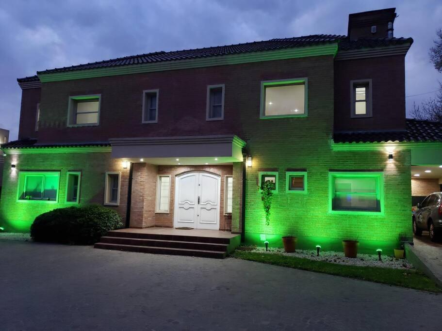 ein Haus mit grüner Beleuchtung an der Vorderseite in der Unterkunft Casa Cerra2 in Villa Leloir