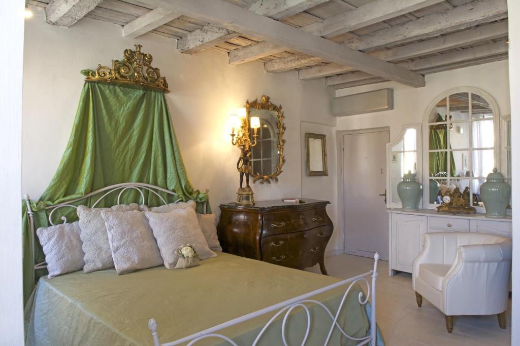 a bedroom with a bed with a green canopy at Le Stanze del Cardinale in Pavia