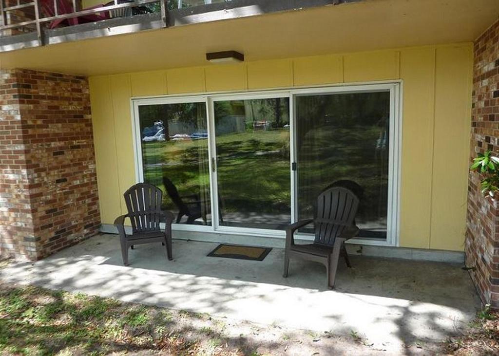 two chairs sitting on the front porch of a house at Atlantic Breeze by Jekyll Realty in Jekyll Island