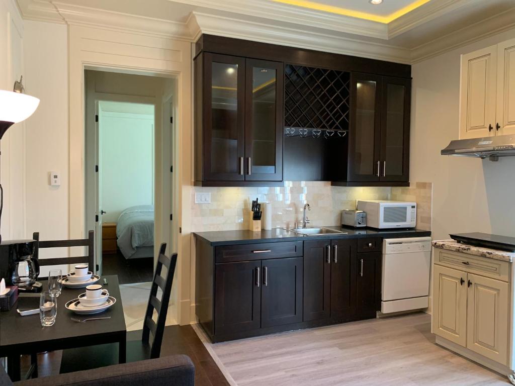 a kitchen with dark brown cabinets and a table with a dining room at Private cozy suite near Dyke and Fisherman's Wharf in Richmond