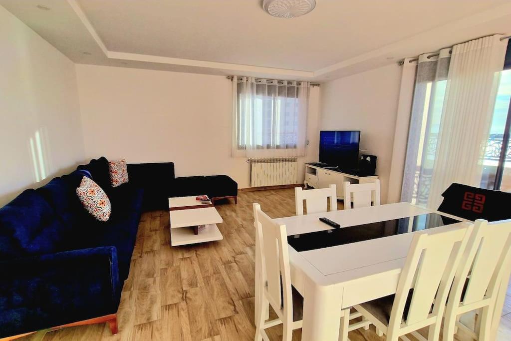 a living room with a blue couch and a table at F4 vue sur mer in Oran