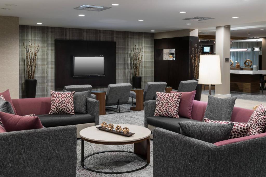 a waiting room with couches and a tv at Courtyard Austin North/Parmer Lane in Austin