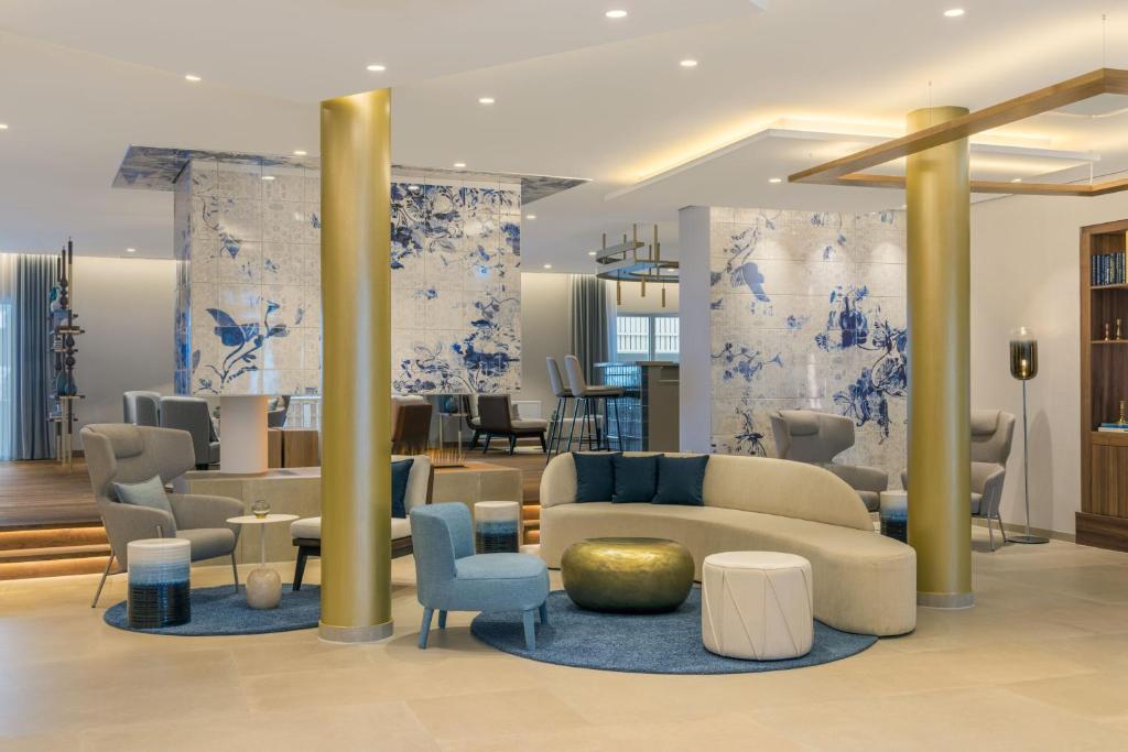 eine Lobby mit blauen und weißen Wänden sowie einem Sofa und Stühlen in der Unterkunft Caro & Selig, Tegernsee, Autograph Collection in Tegernsee
