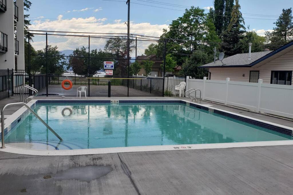 - une piscine d'eau bleue dans la cour dans l'établissement Lakeside studio with pool, à Vernon