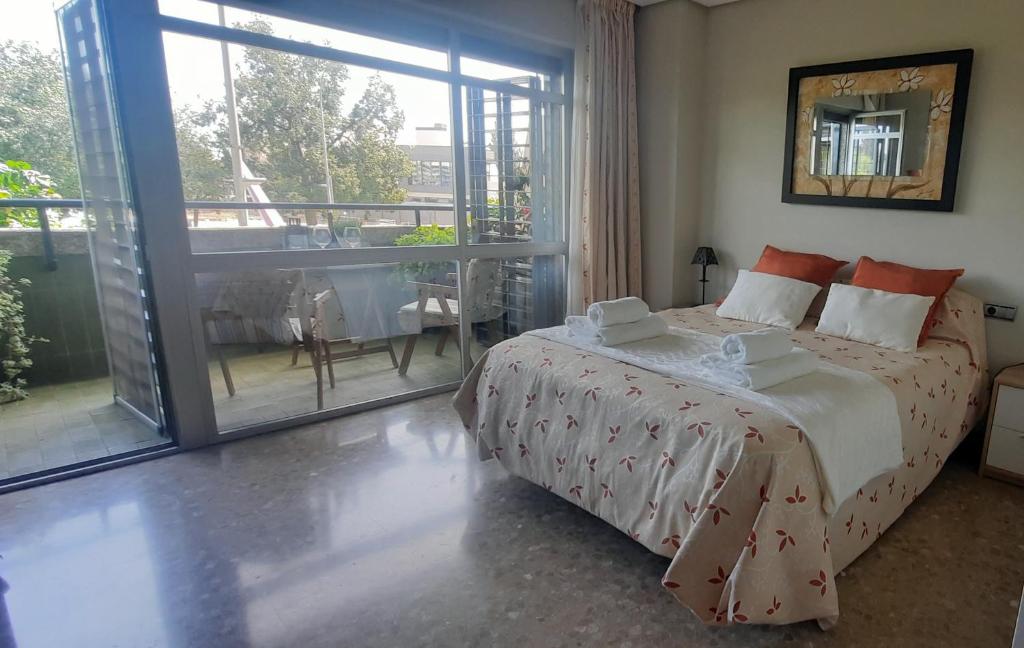 1 dormitorio con 1 cama grande y balcón en Feria apartment, near Plaza España, en Sevilla