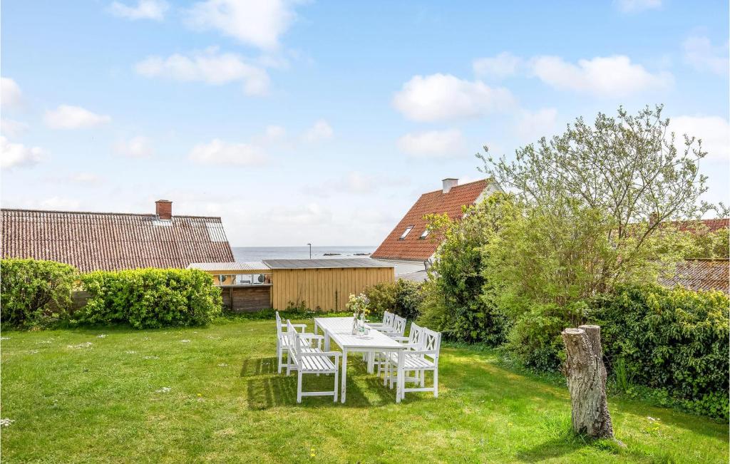 a table and chairs in the yard of a house at 1 Bedroom Gorgeous Apartment In Svaneke in Svaneke