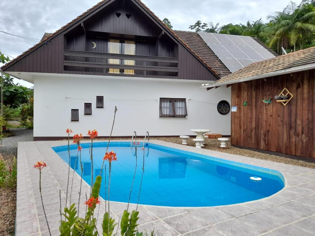 a house with a swimming pool in front of it at Hospedagem Tia Marli in Pomerode