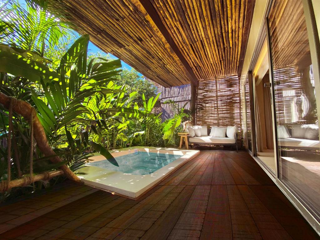 a hot tub in the middle of a room with plants at Hotel Shibari - Restaurant & Cenote Club in Tulum