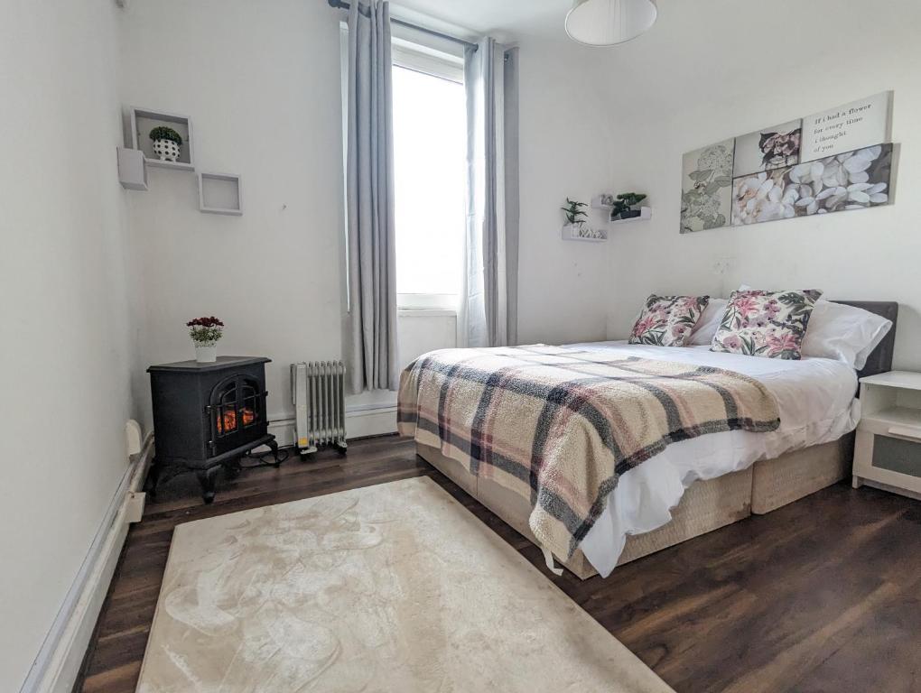 a bedroom with a bed and a fireplace in it at Whitchurch 1 Bedroom Apartment in Cardiff
