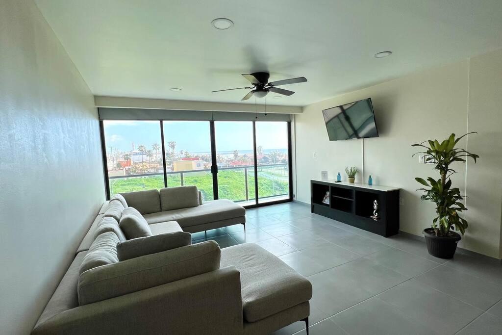 sala de estar con 2 sofás y ventilador de techo en Luxury 2BR Condo (F) Rosarito, en Rosarito