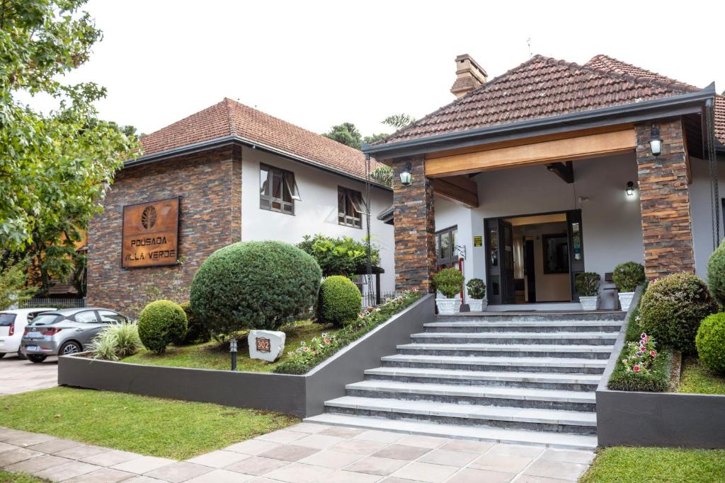 a house with a staircase in front of it at Pousada Villa Verde in Canela