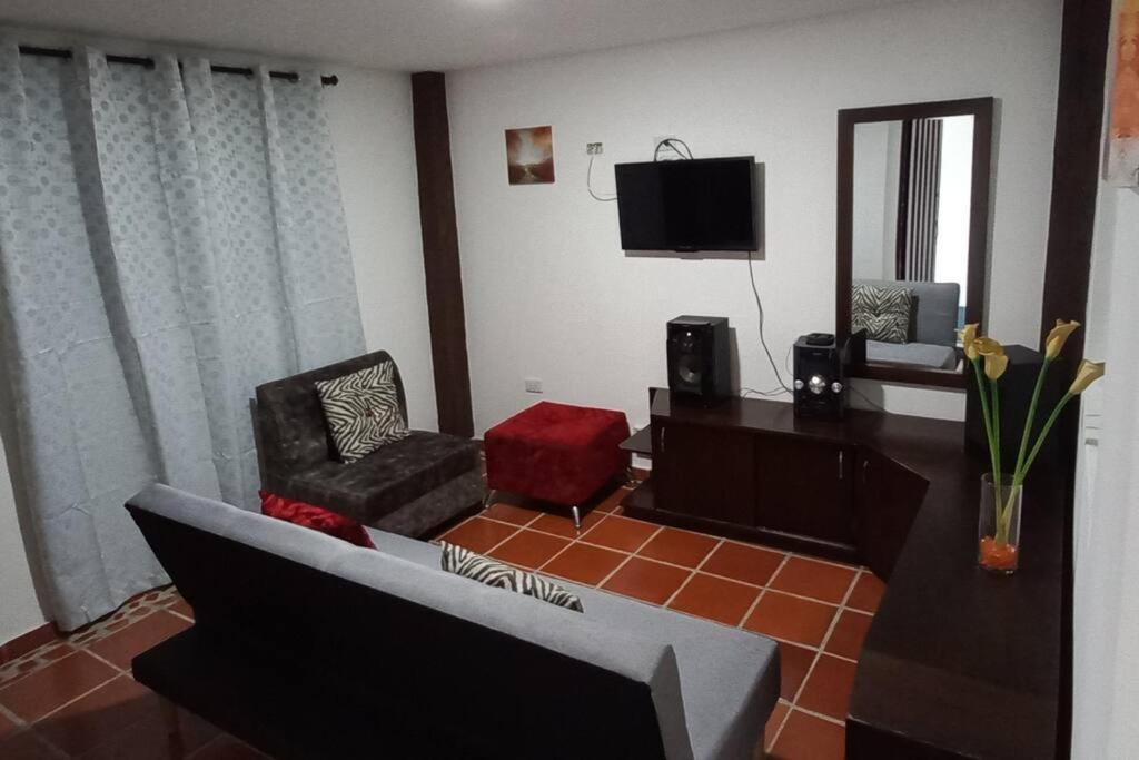 sala de estar con sofá y TV en Apartamento amoblado nuevo en Guadalajara de Buga, en Buga