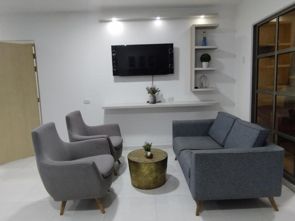a living room with two chairs and a tv at Apartamento con ubicación estratégica in Cartagena de Indias