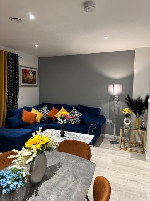 uma sala de estar com um sofá azul e uma mesa em Beautiful 3 Bedroom Duplex Apartment with Balcony em North Woolwich