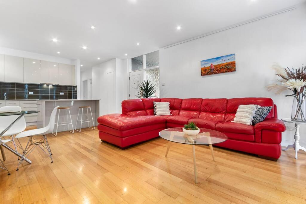 a living room with a red couch and a table at Tranquil apartment in the city in Newcastle