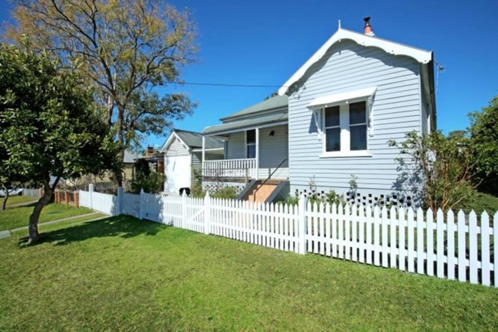 a white picket fence in front of a white house at Nowra Beauty in Nowra
