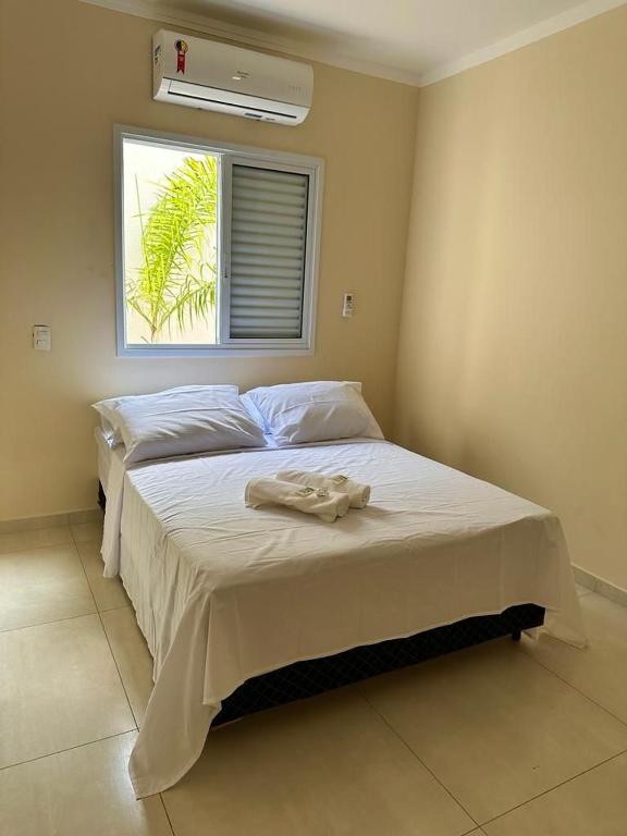 a bedroom with two beds and a window at KITNET 1001 Apart Hotel in Piracicaba